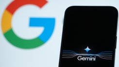 Gemini logo on smartphone in front of Google logo 