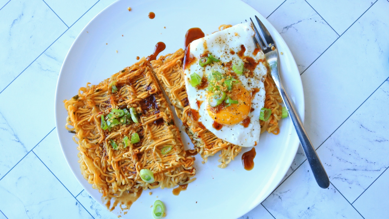 Waffled ramen on a plate with an egg.