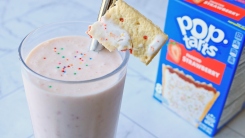 A milkshake in front of a box of strawberry Pop-Tarts.