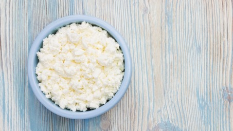 A bowl of cottage cheese on a wooden table