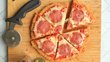 A pizza sliced on a cutting board.