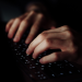 Close-up image of a computer keyboard with hands typing in dim light