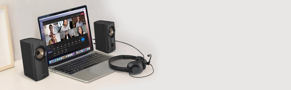 desktop setup of a laptop with creative t60 speakers, and a 3.5mm headset connected to the speakers