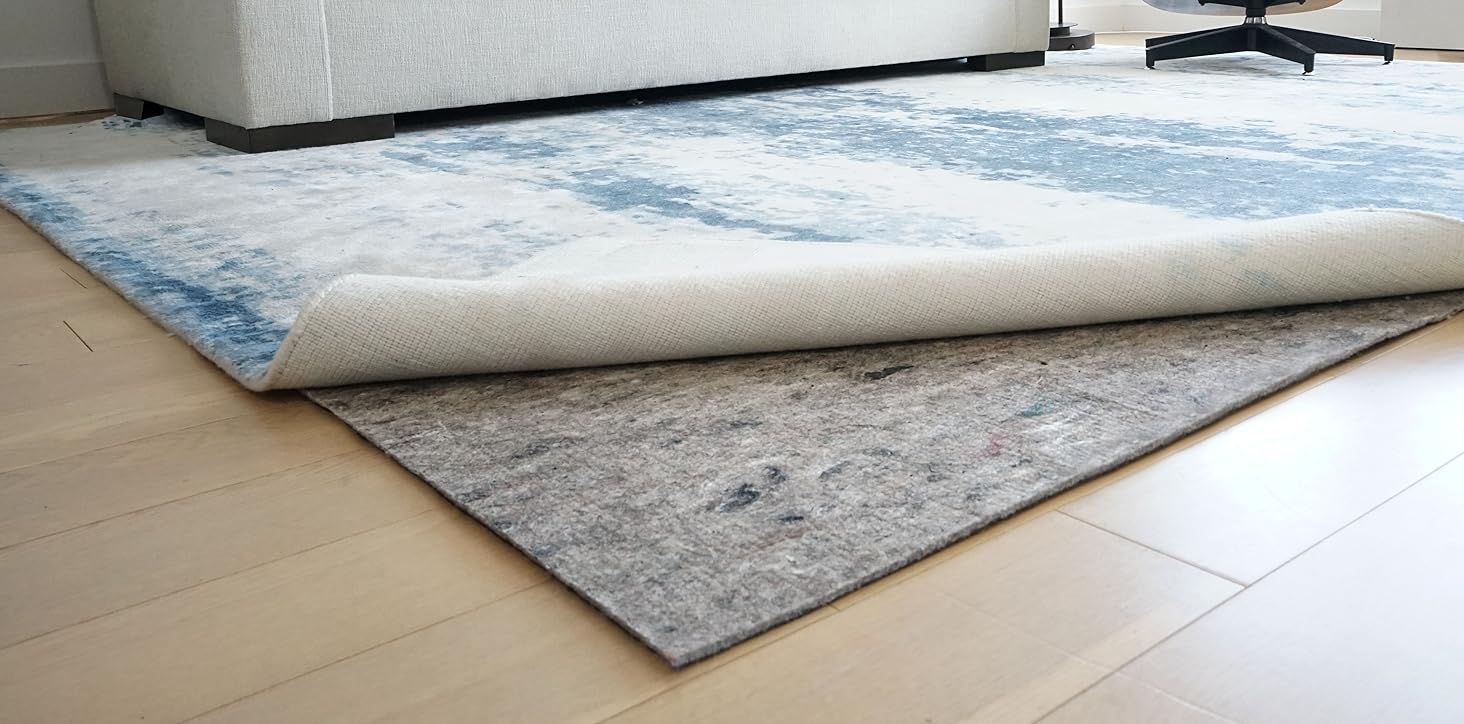 Rug pad in a living room under a rug with a white couch