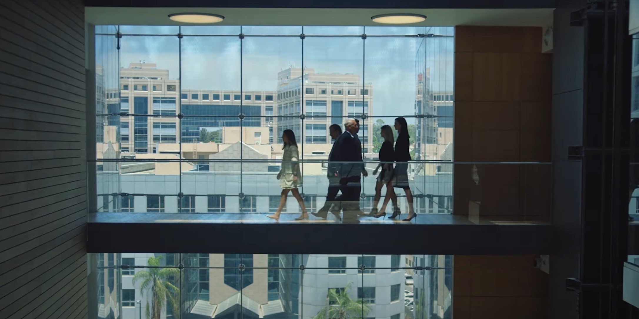 A group of professionals walk down a hallway in a Moody's office building.