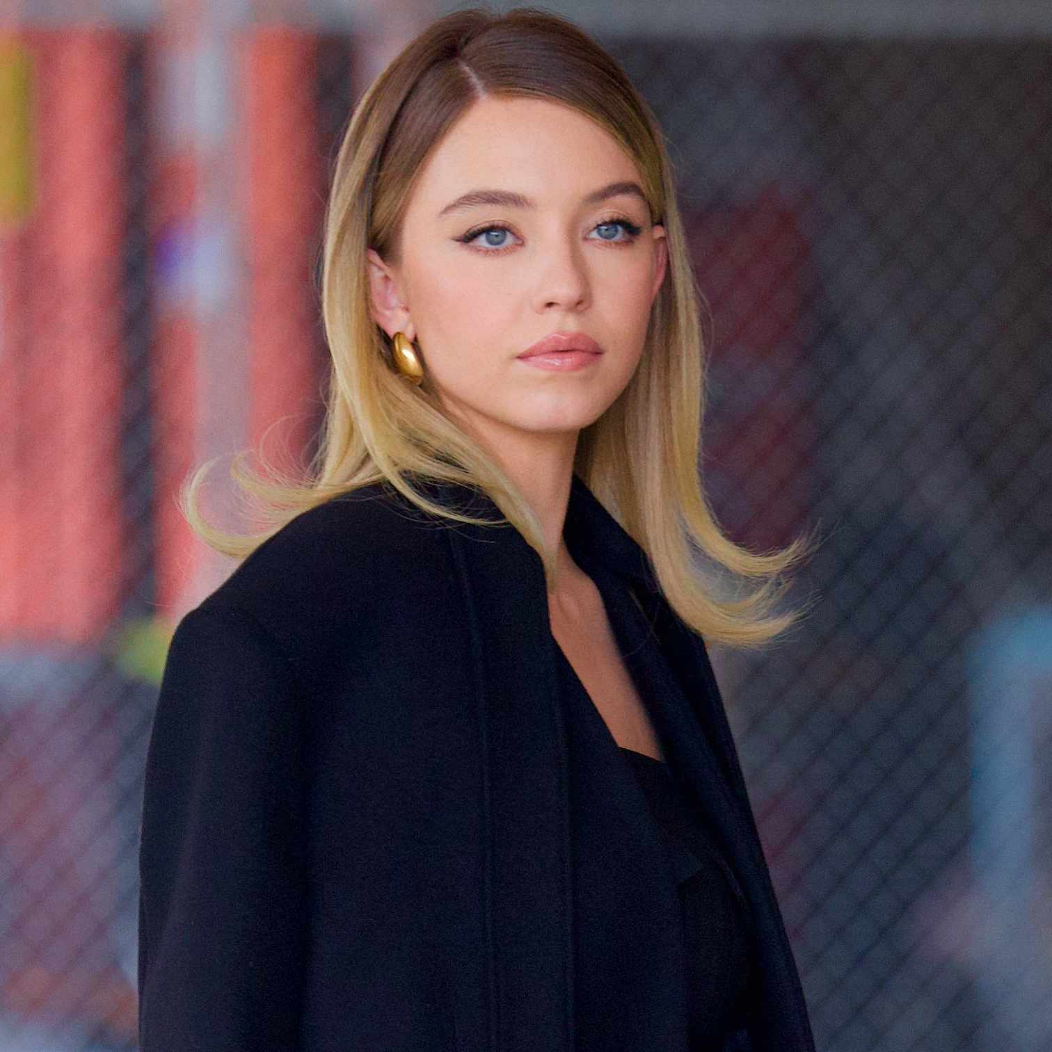 Sydney Sweeney was spotted departing an interview on Thursday afternoon, looking glamorous in a black Balmain jumpsuit with a long Givenchy coat draped across her shoulders. 