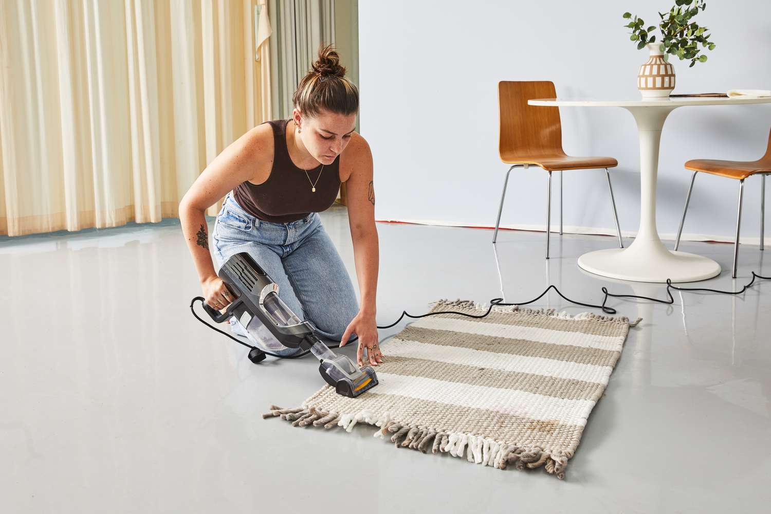 A person vacuuming the Rugs.com Washable Eco Plaid Indoor/Outdoor Rug