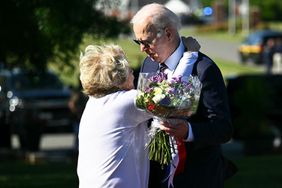 Joe Biden embraces former Delaware State Senator Nancy Cook as he arrives with flowers at Veterans Memorial Park in New Castle, Delaware on May 30, 2024.