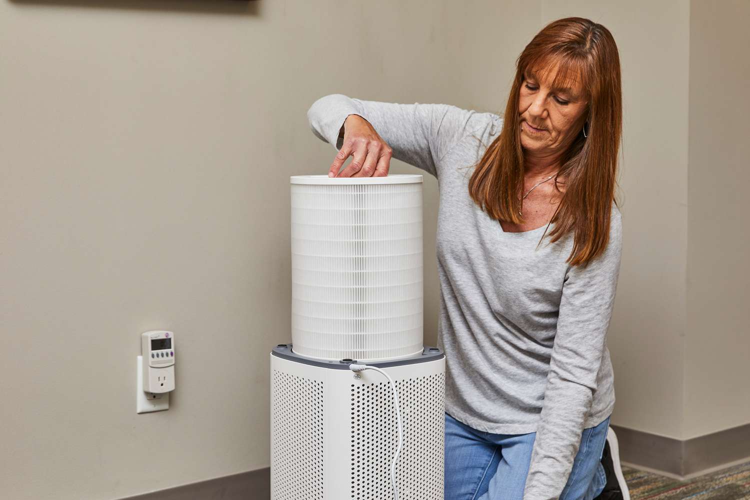 A person pulls the filter out of the Clorox Large Room True HEPA Air Purifier.