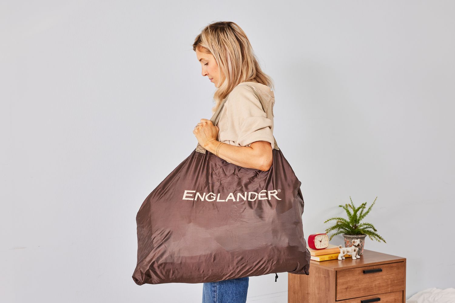 A person carries the Englander Air Mattress in a bag