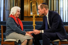 Prince William, Prince of Wales touches the hand of 94-year-old Renee Salt, a Holocaust survivor, during a visit to the Western Marble Arch Synagogue