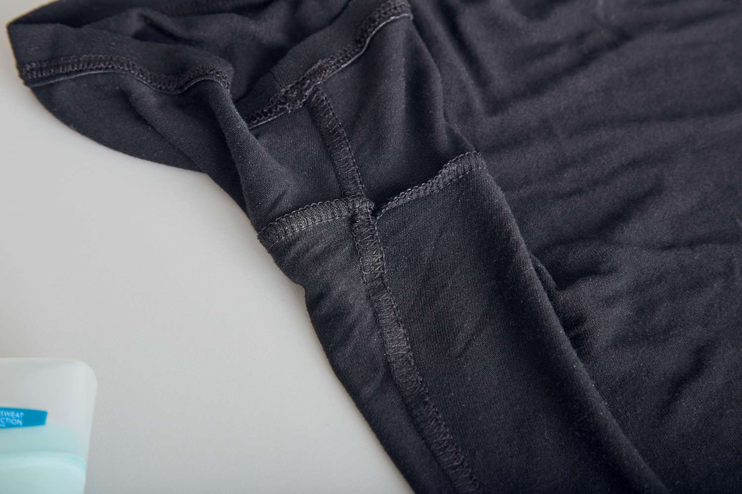 Closeup of the underarm of an inside out black T-shirt
