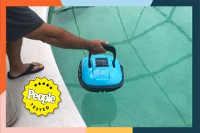 A person placing the Wybot Cordless Robotic Pool Cleaner into a pool