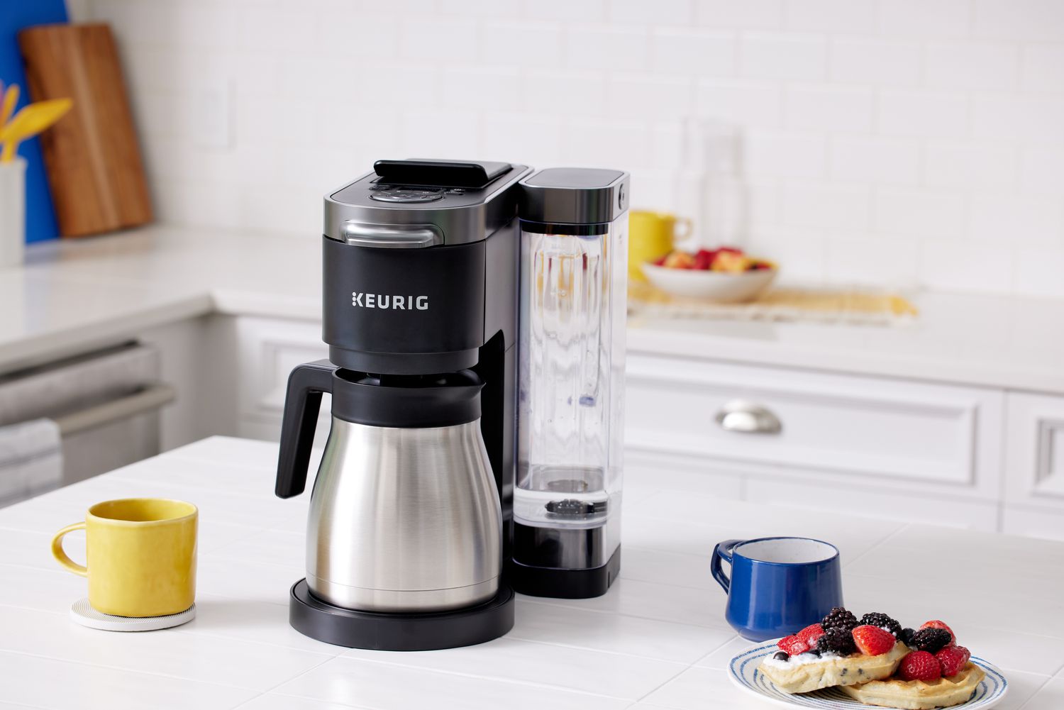 Keurig K-Duo Plus Coffee Maker on a kitchen counter next to a coffee mug and a plate with waffles and berries