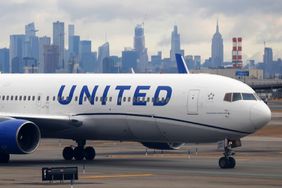 A United Airlines airplane proceeds to a gate at Newark Liberty International Airport in front of the skyline of midtown Manhattan and the Empire State Building in New York City on January 27, 2024, in Newark, New Jersey.