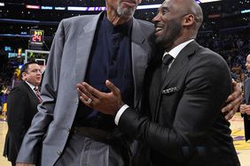 Kobe Bryant and Kareem Abdul-Jabbar shshare a moment at halftime after both of Bryant's #8 and #24 Los Angeles Lakers jerseys are retired at Staples Center on December 18, 2017 in Los Angeles, California.