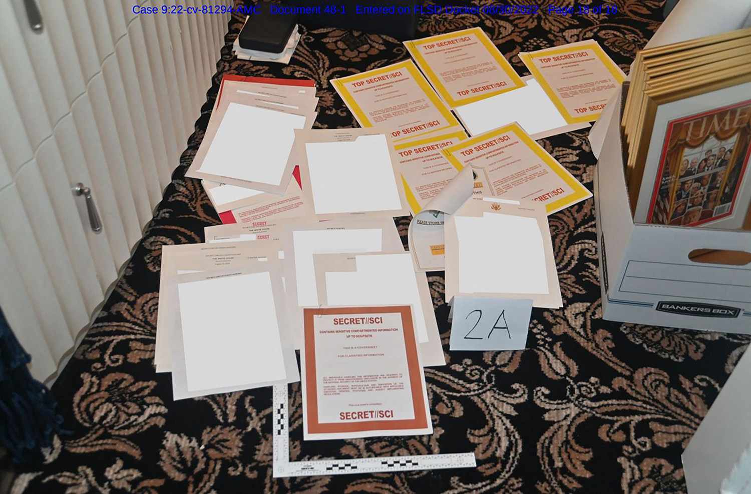 This undated image released by the US Department of Justice, shows a photo attached as evidence to a court filing by the US District Court Southern District of Florida, of documents allegedly seized at Mar-a-Lago spread over a carpet. - Documents at former US President Donald Trump's Florida home were "likely concealed" to obstruct an FBI probe into his potential mishandling of classified materials, the Department of Justice said in a court filing August 30, 2022. The filing provides the most detailed account yet of the motivation for the FBI raid this month on Trump's Mar-a-Lago estate, which was triggered by a review of records he previously surrendered to authorities that contained top secret information
