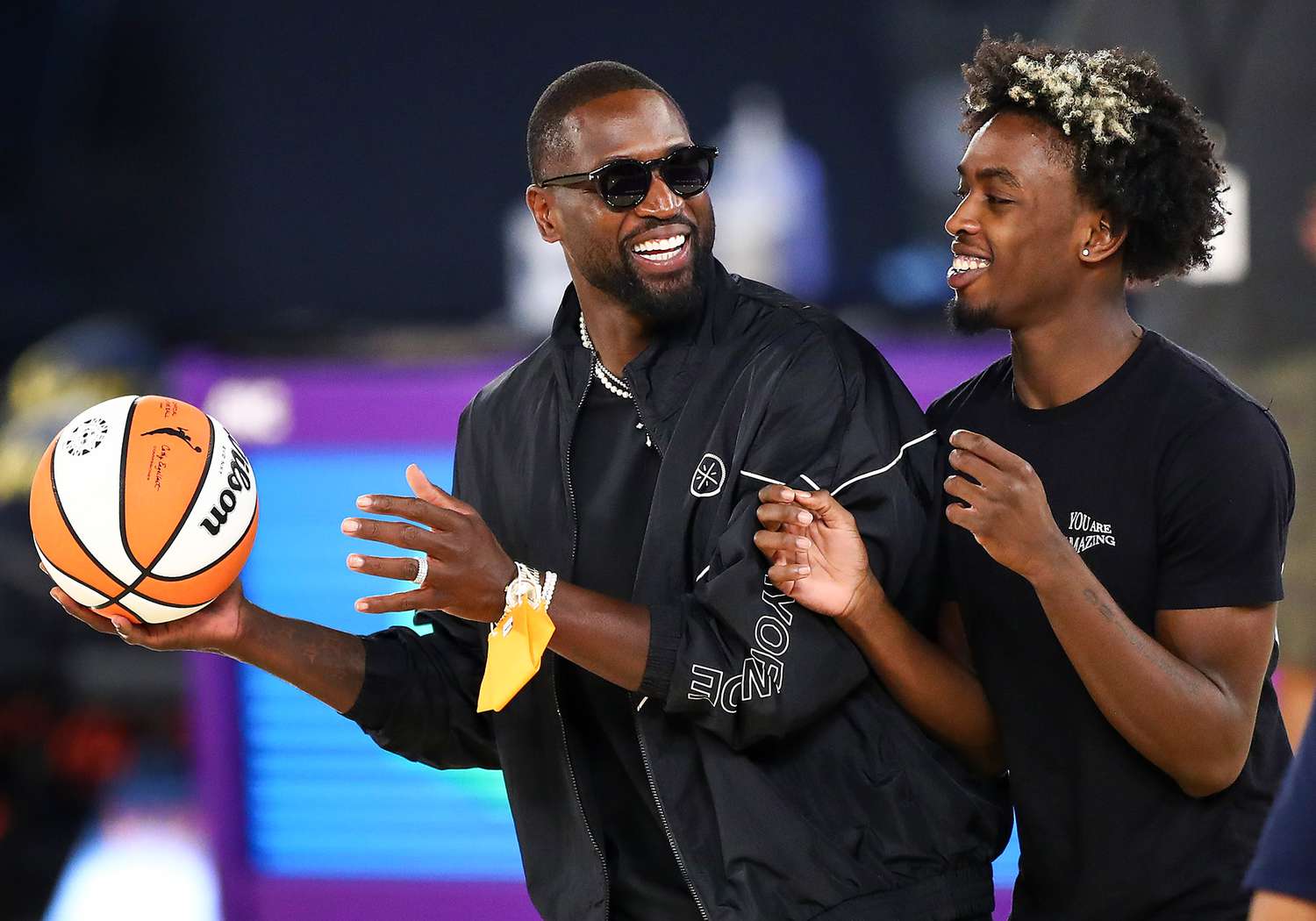 Dwyane Wade and his son Zaire Wade spend time on the court after the game between the Los Angeles Sparks and the Las Vegas Aces at Los Angeles Convention Center on June 30, 2021 in Los Angeles, California
