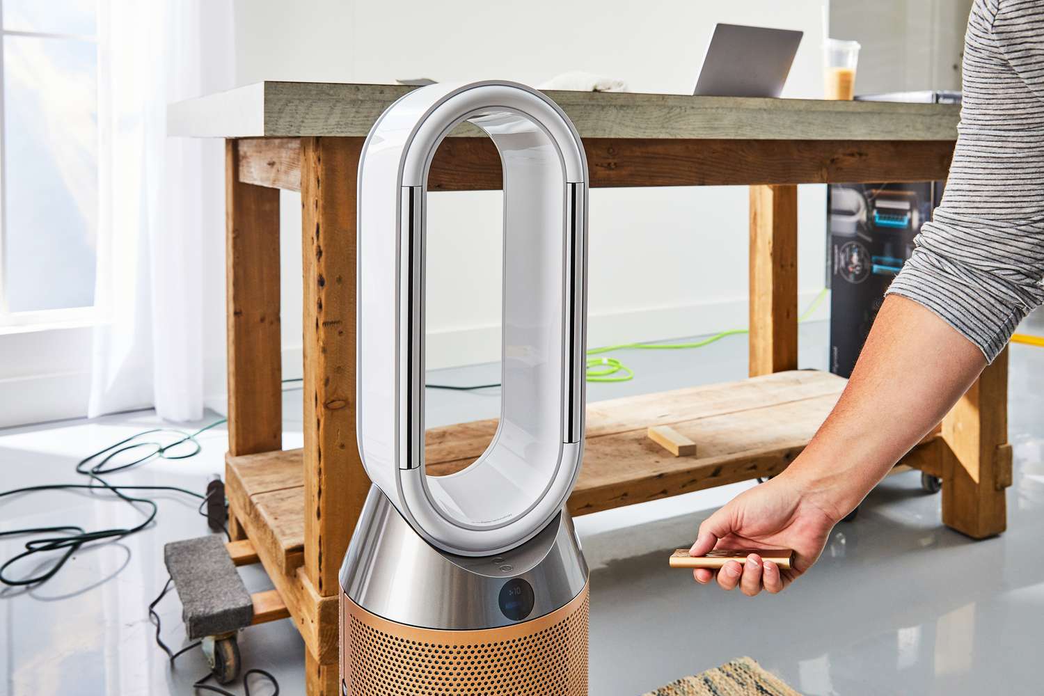 Person pressing a remote for a Dyson Purifier Humidify+Cool Formaldehyde PH04 with table nearby