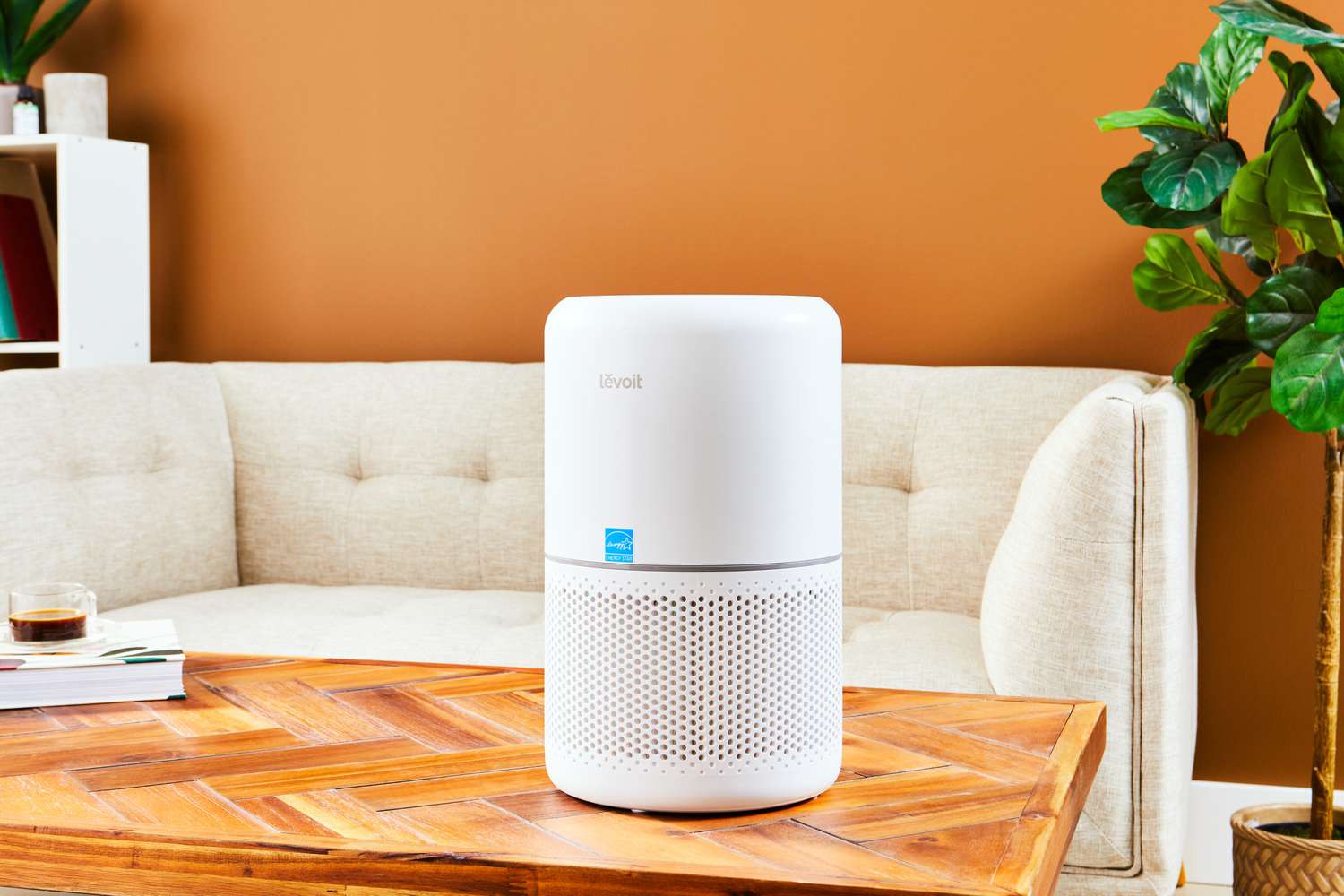 The Levoit Core 300S Smart True HEPA Air Purifier stylized on a wooden table