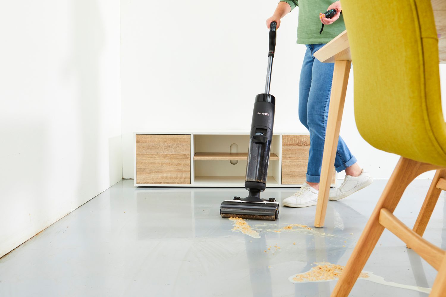 A person using the Tineco Floor One S7 Pro Smart Wet Dry Vacuum Cleaner to clean up mess on floor