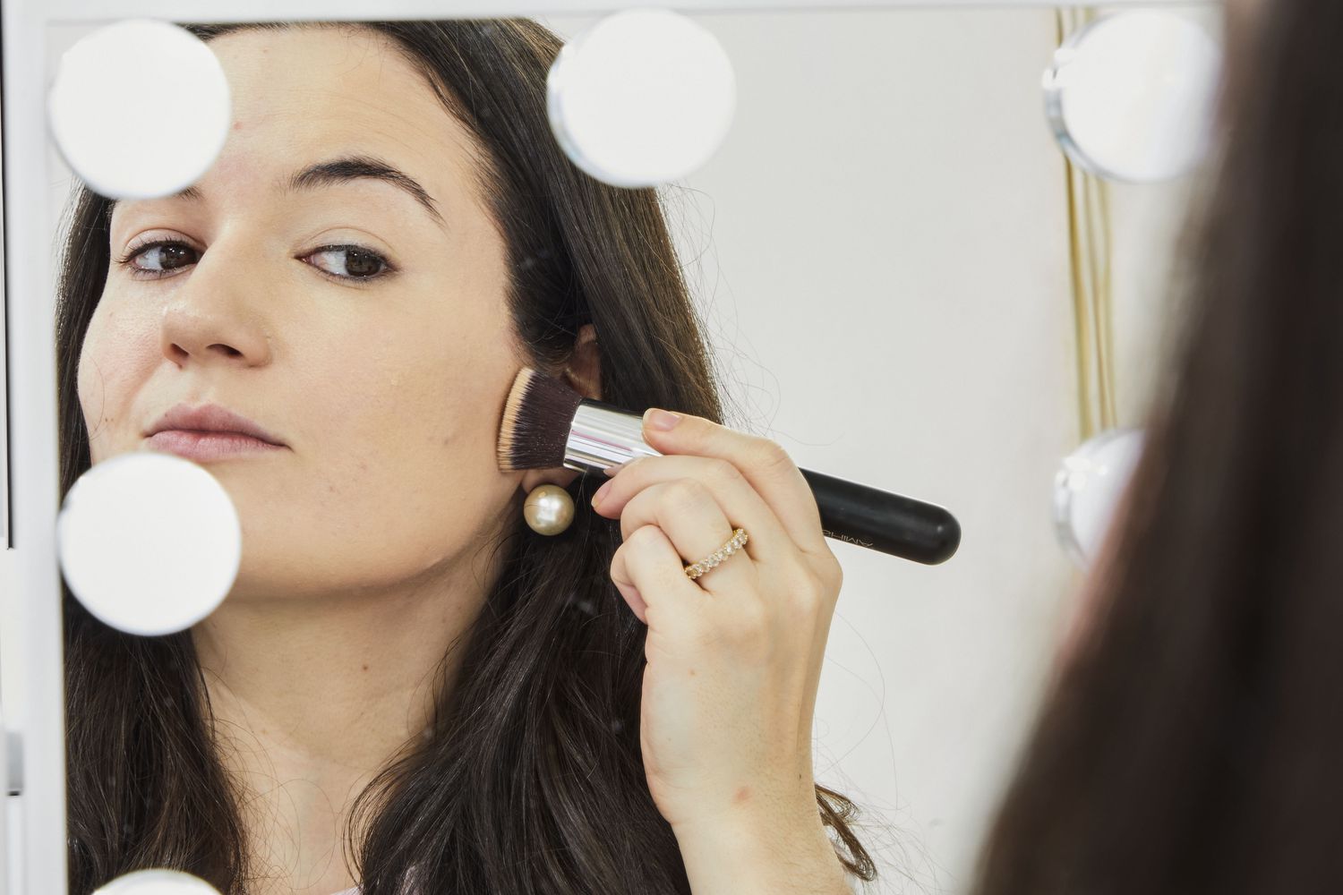 person brushes Shiseido Synchro Skin Self-Refreshing Foundation onto cheeck