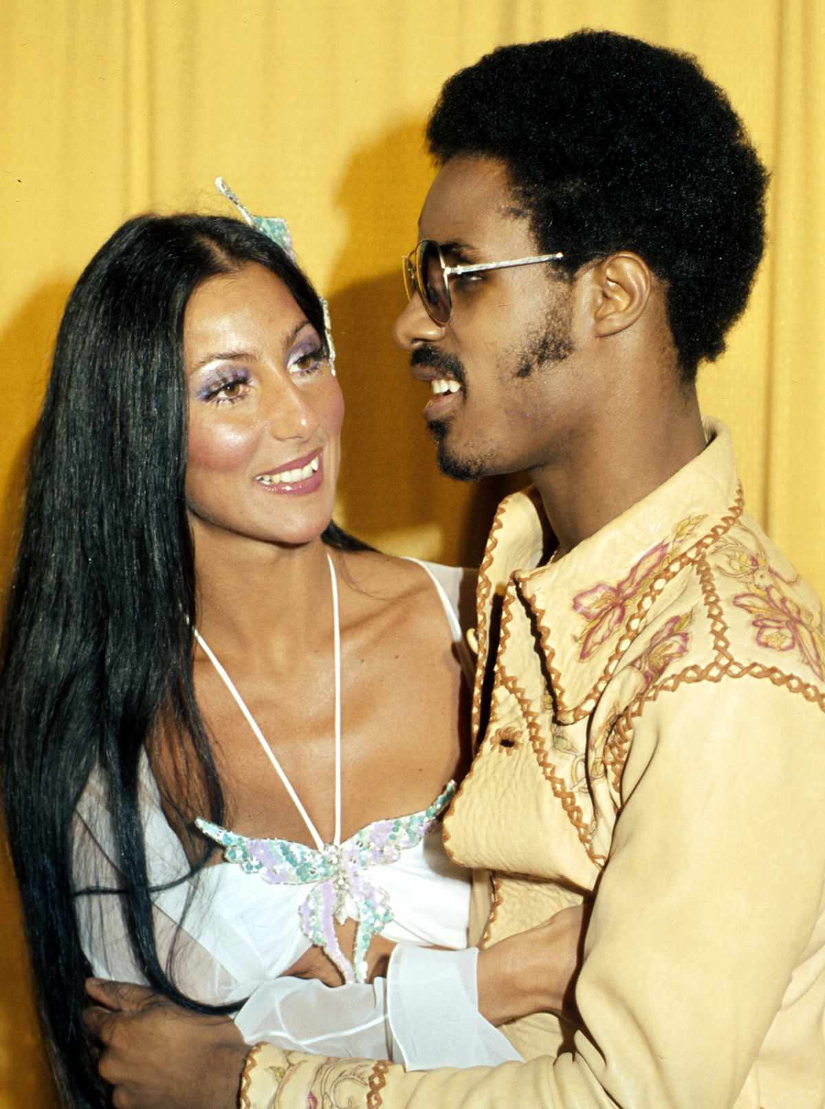 Entertainers Cher and Stevie Wonder attend the Grammy awards wearing a large butterfly pin in her hair on March 2, 1974 in Los Angeles, California