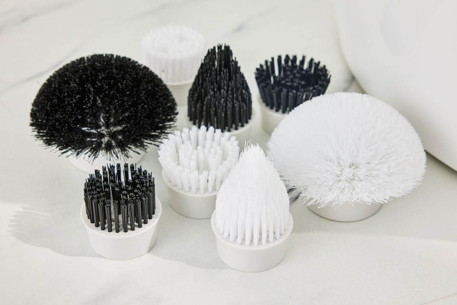 The various attachments for a Klever Electric Spin Scrubber with 8 Brushes on a white surface
