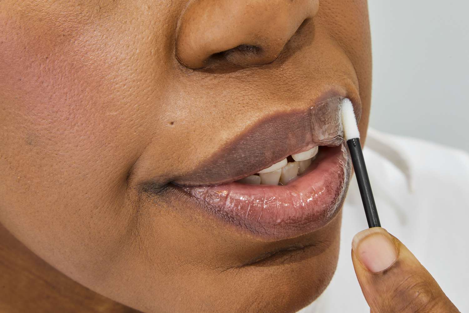 Woman applying Cay Skin Isle Lip Balm SPF 30 with Sea Moss and Aloe Stem Cells