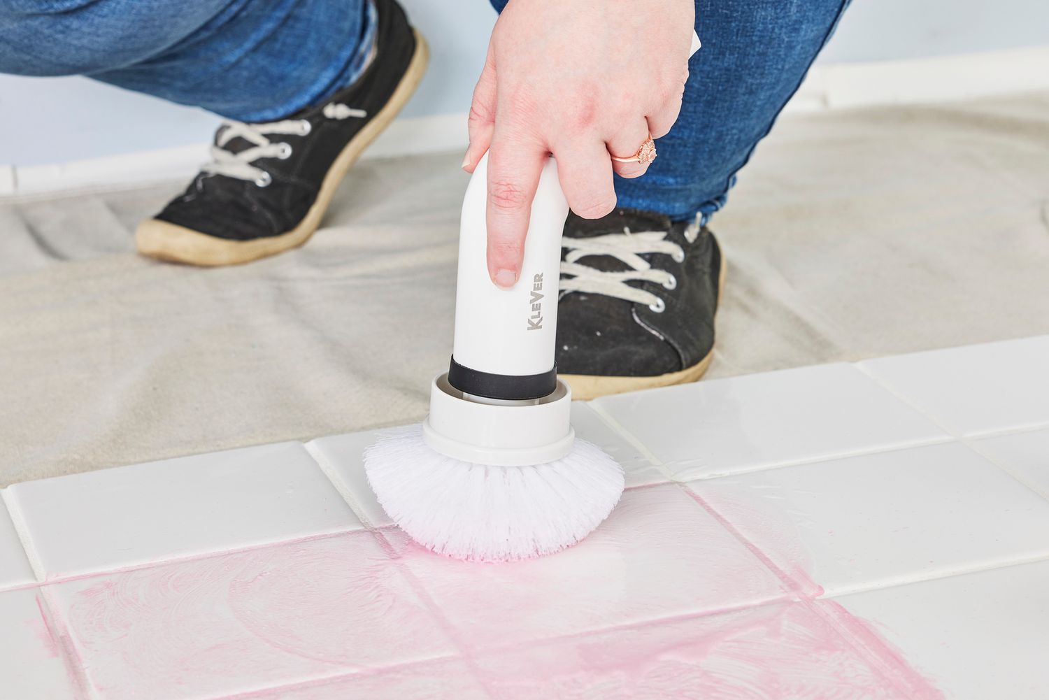 Person cleans white tile stained with red marker with a Klever Electric Spin Scrubber with 8 Brushes