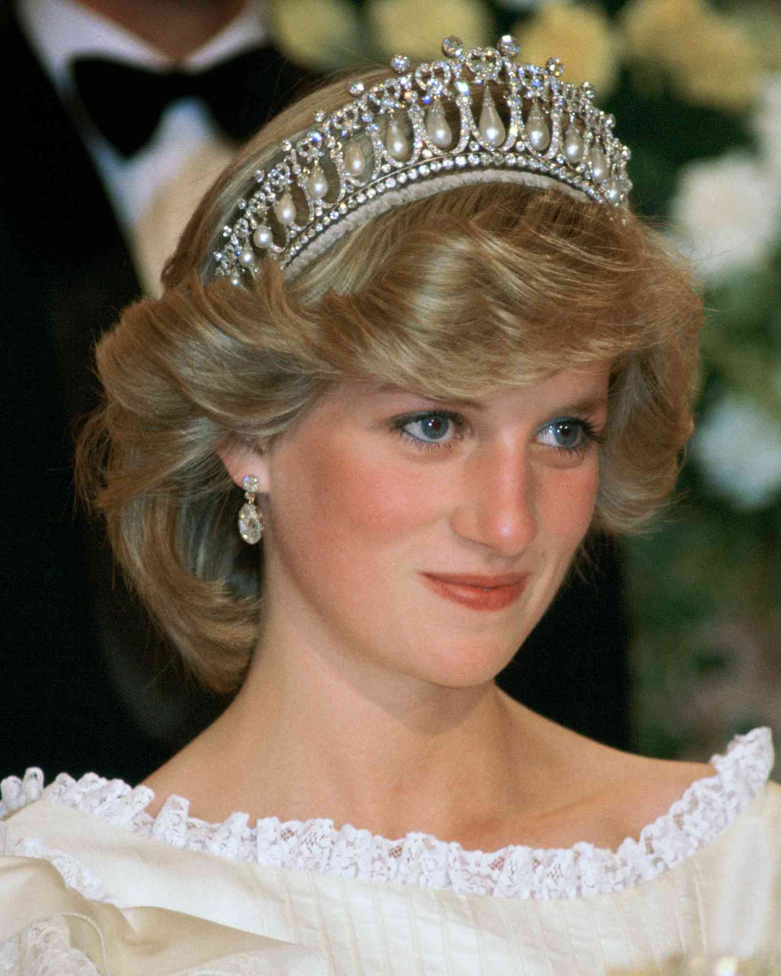 Princess Diana At A Banquet In New Zealand Wearing The Cambridge Knot Tiara ( Queen Mary's Tiara ) With Diamond Earrings. Her Cream Silk Organza Evening Dress Is Designed By Fashion Designer Gina Fratini