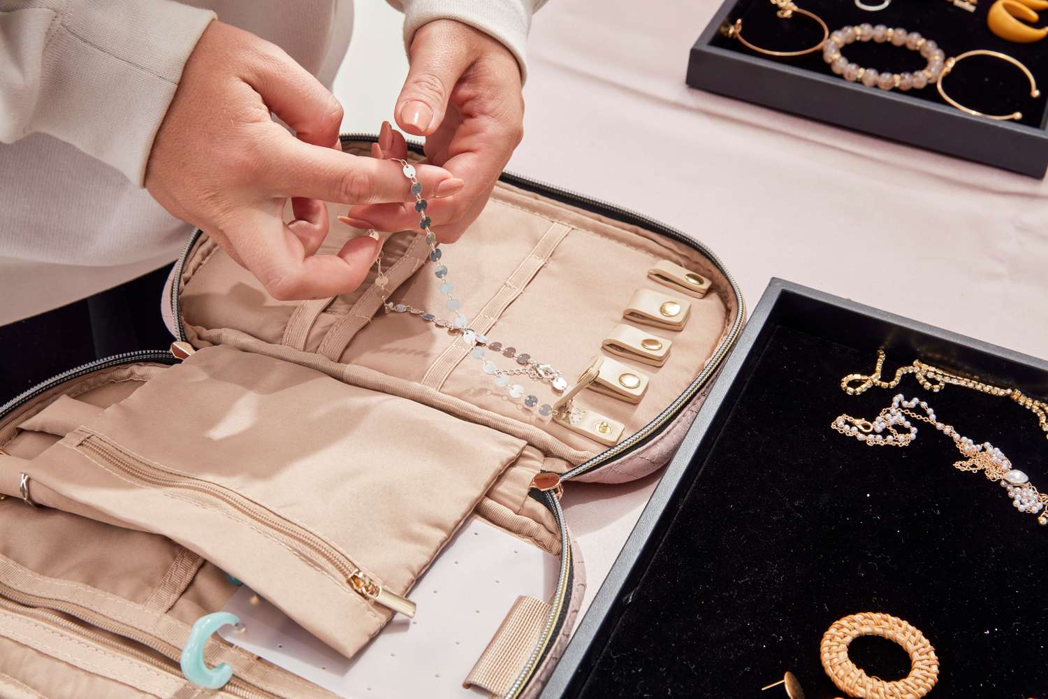 A person putting jewelry into the Bagsmart Jewelry Organizer Bag.