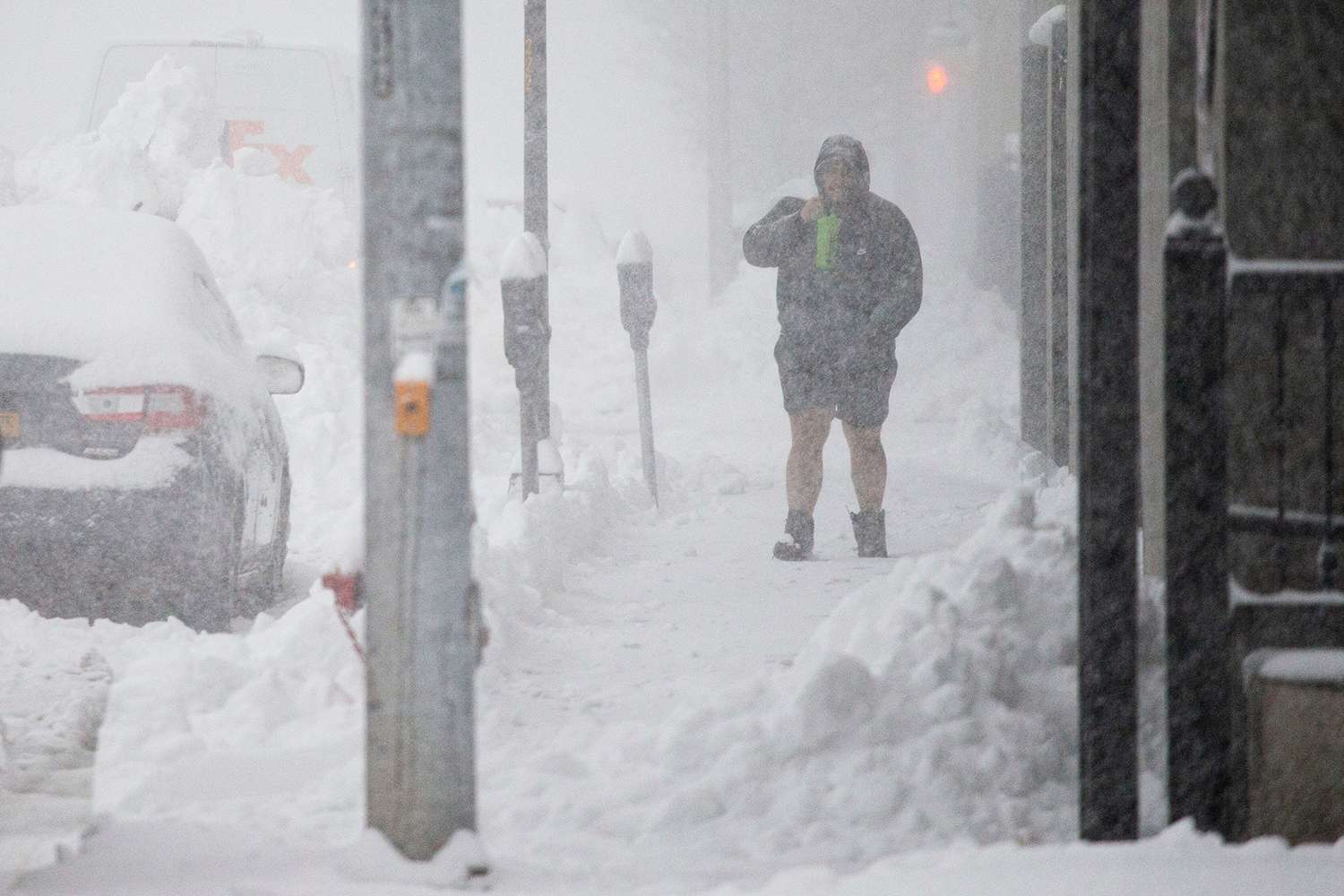 Person walks through downtown in the snow, in Buffalo, N.Y. A dangerous lake-effect snowstorm paralyzed parts of western and northern New York, with nearly 2 feet of snow already on the ground in some places and possibly much more on the way