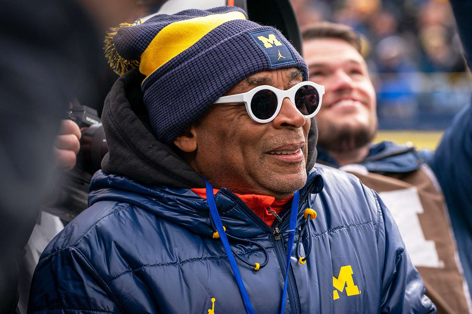 Spike Lee looks on as Colin Kaepernick greets fans before the Michigan spring football game at Michigan Stadium on April 2, 2022 in Ann Arbor, Michigan.
