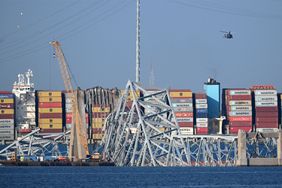 A crane begins clean-up at the collapsed Francis Scott Key Bridge after it was struck by the container ship Dali, in Baltimore, Maryland, on March 29, 2024.