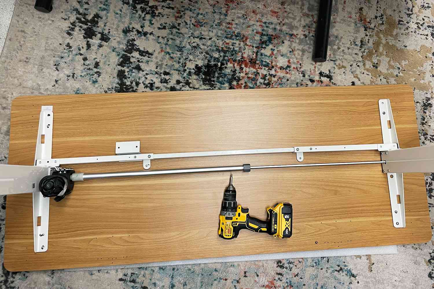 FlexiSpot EN1 Electric Height Adjustable Desk being assembled with a drill on the floor