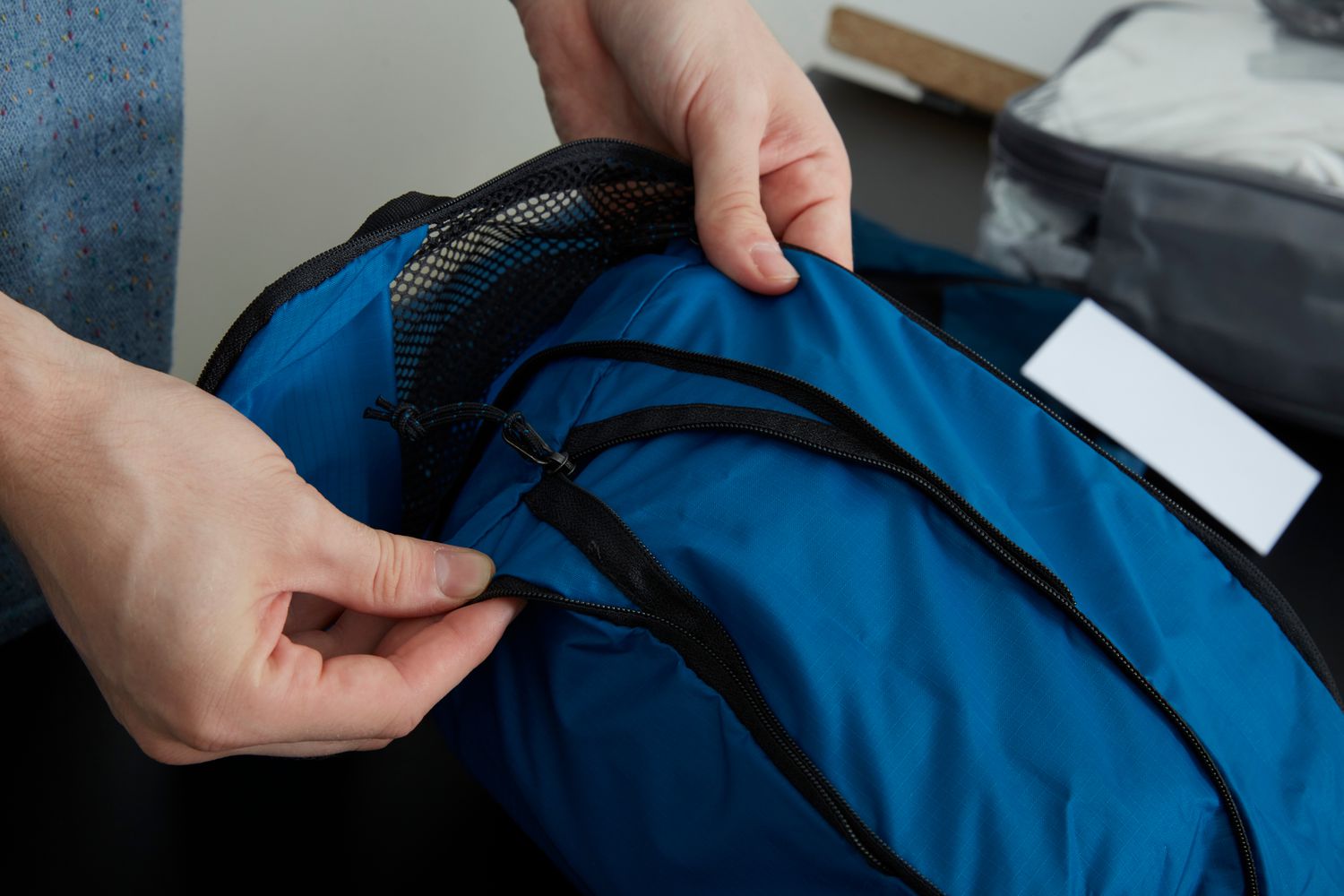 Person inspecting zipper on an REI Co-op Expandable Packing Cube