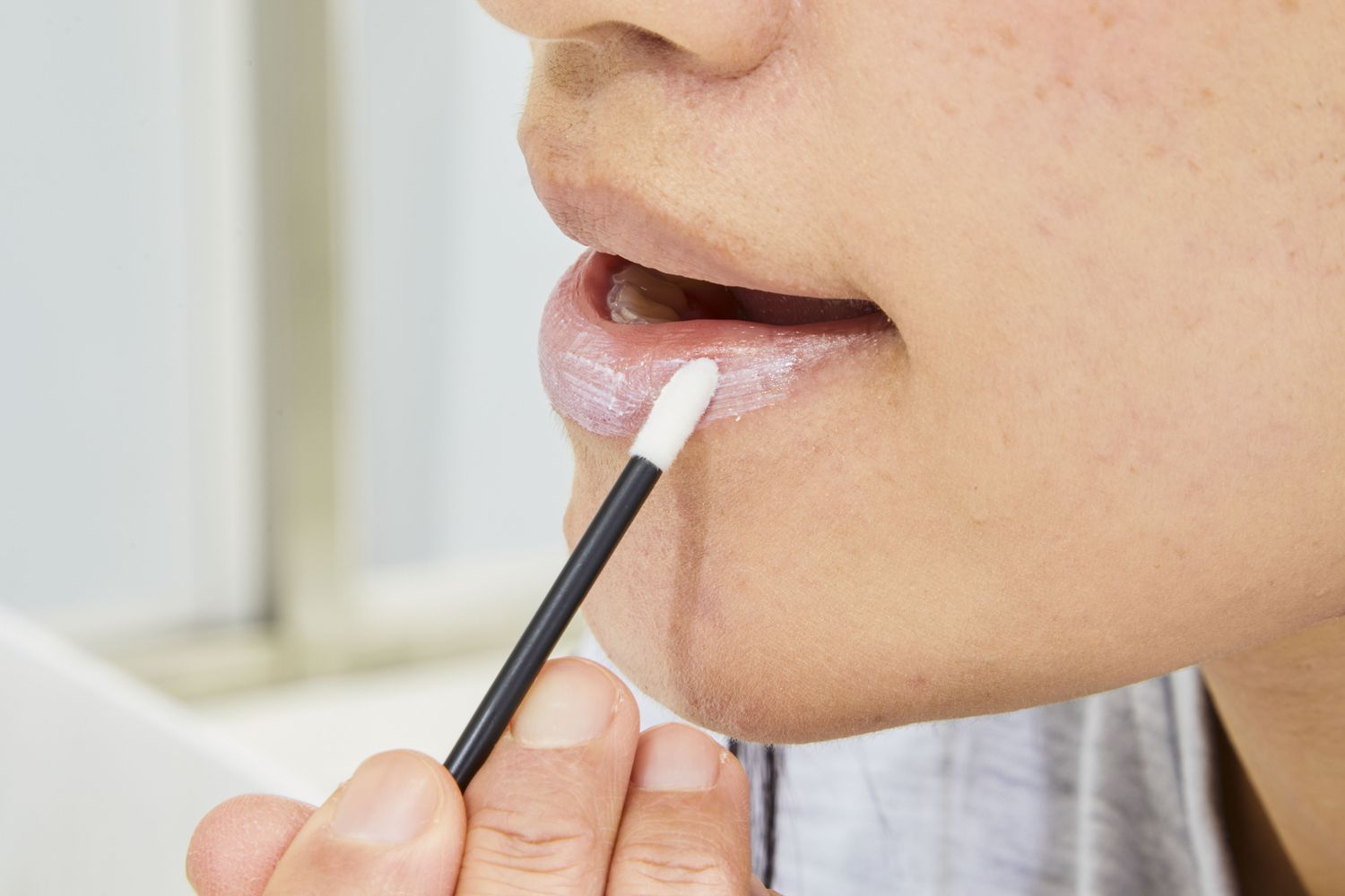 Woman applying EltaMD UV Lip Balm Broad-Spectrum SPF 36 on her lips