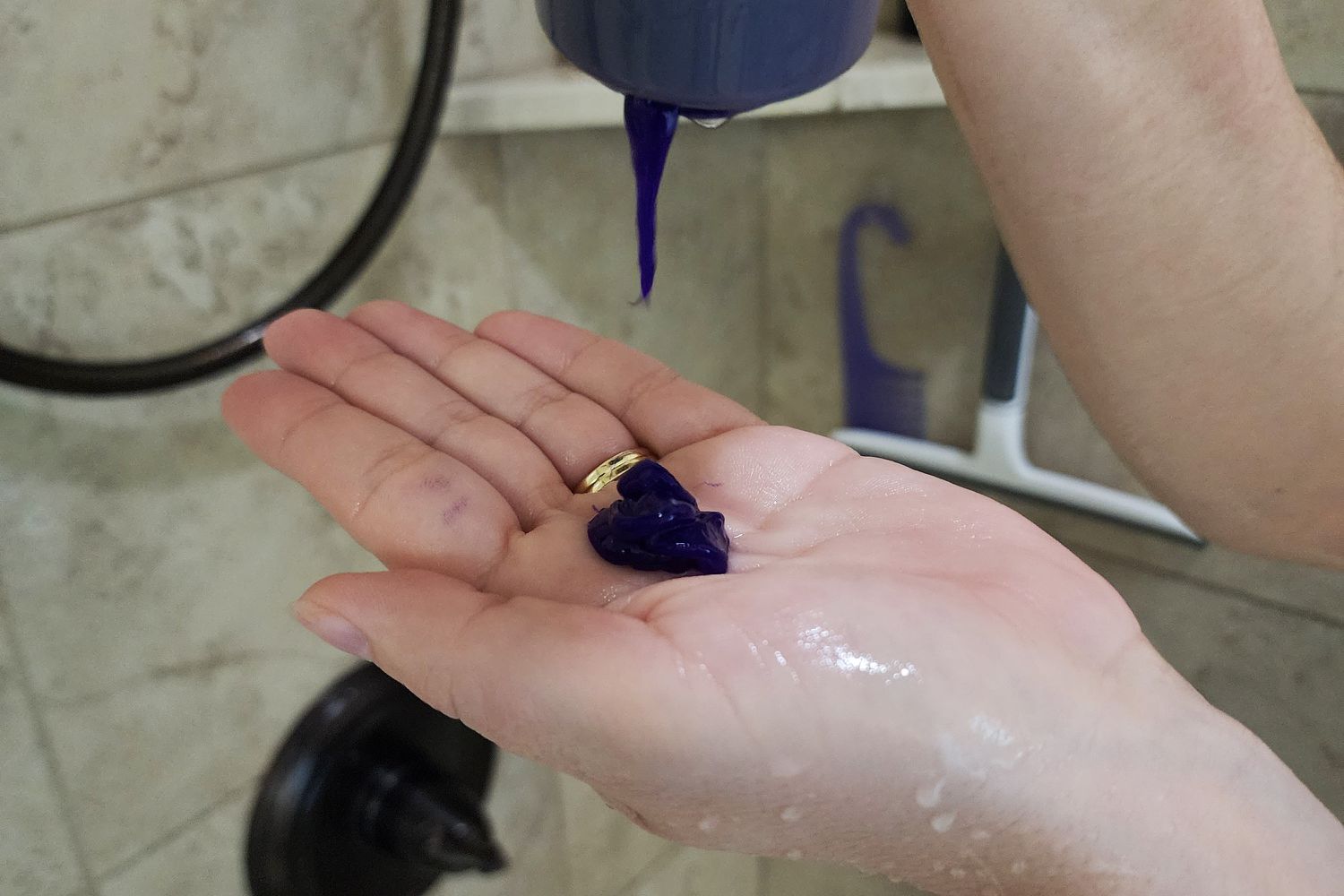 Kristin Ess The One Purple Shampoo squeezed into the palm of a hand 