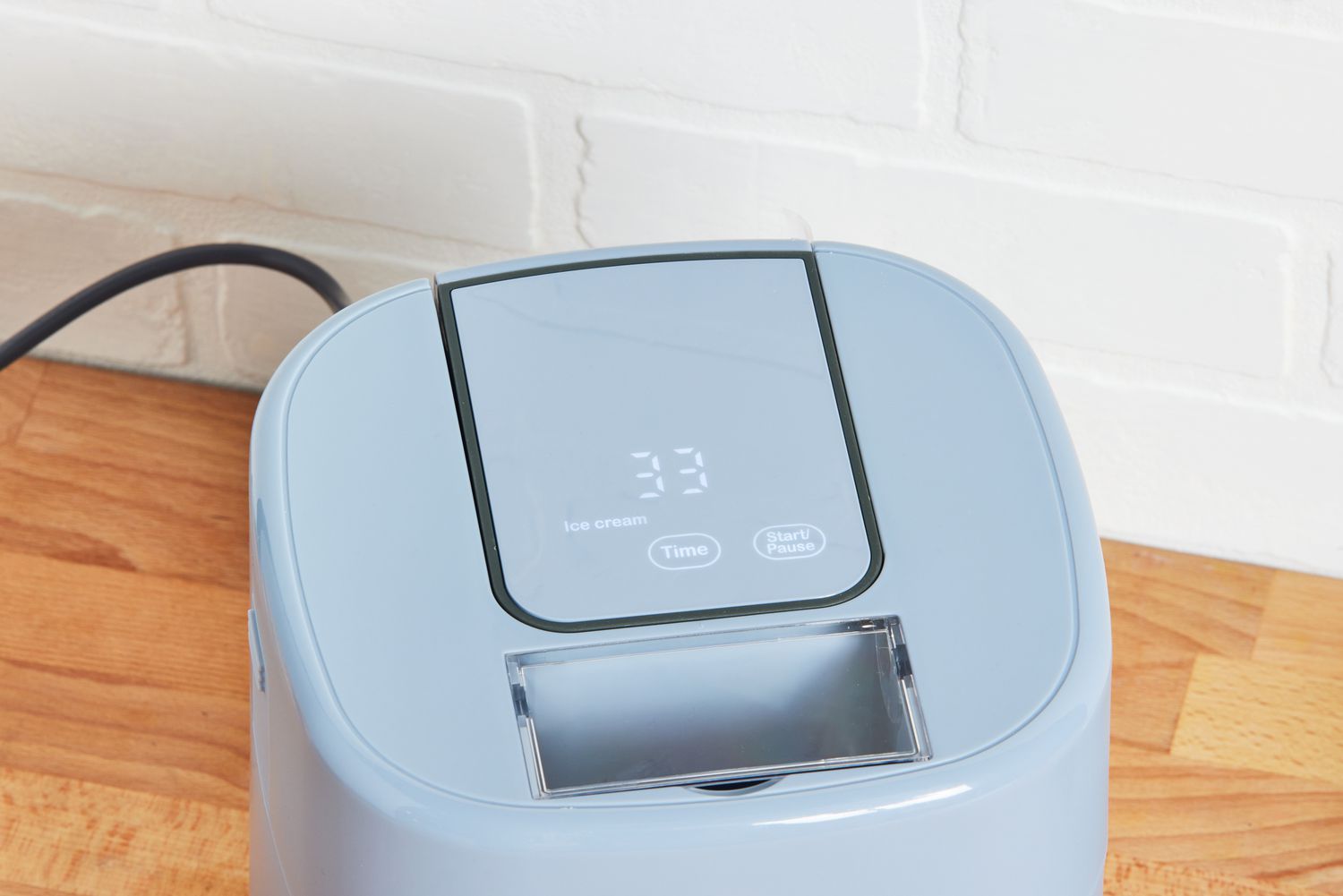 The Beautiful by Drew Barrymore Ice Cream Maker sitting on a counter with the touchscreen display on