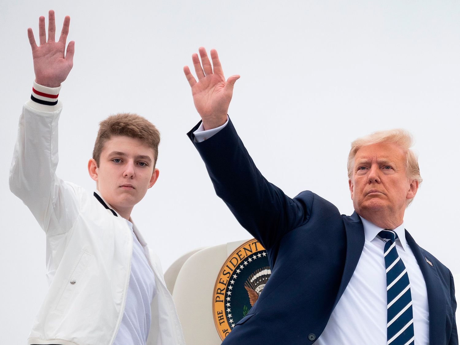 US President Donald Trump and his son Barron wave as they board Air Force One