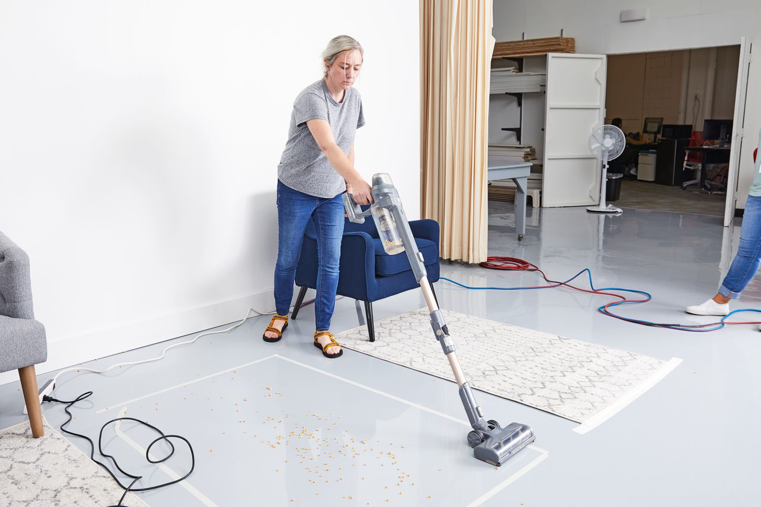 Woman using Kenmore DS4095 Elite Cordless Stick Vacuum with EasyReach Wand to clean floor