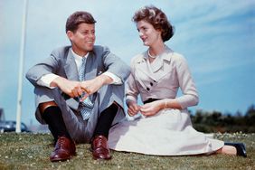 John F. Kennedy and Jacqueline Bouvier sit together in the sunshine at Kennedy's family home at Hyannis Port, Massachusetts, a few months before their wedding.