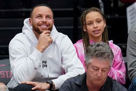 Golden State Warriors' Stephen Curry, second from right, and his daughter Riley, right, sit courtside during the first half of an NCAA college basketball game between Stanford and Southern California in Stanford, Calif., Friday, Feb. 17, 2023. (AP Photo/Godofredo A. Vásquez)