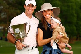 Rory McIlroy of Northern Ireland celebrates with the trophy alongside his wife Erica and daughter Poppy after winning during the final round of the 2021 Wells Fargo Championship