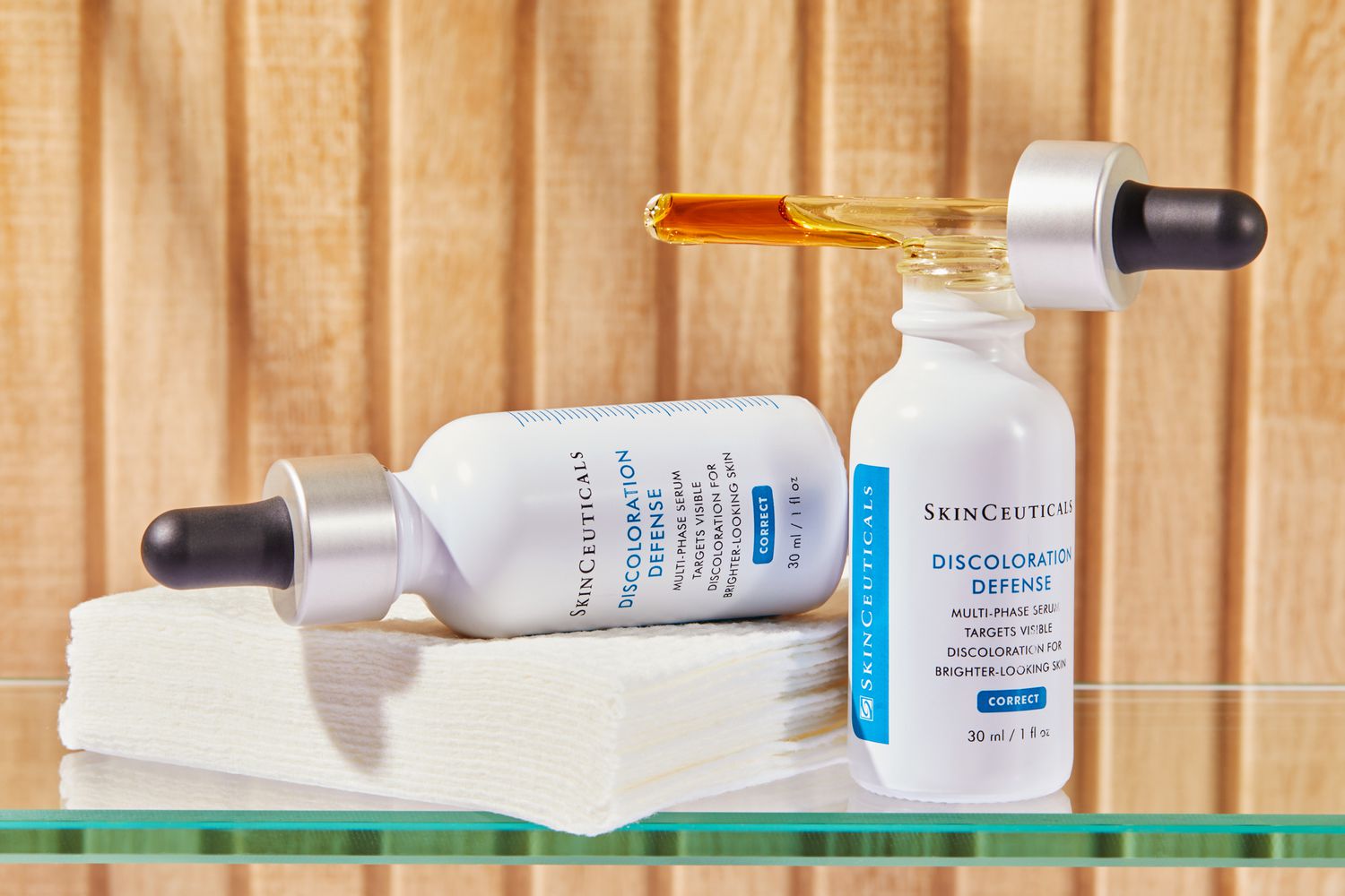 two bottles of Skinceuticals Discoloration Defense on glass shelf