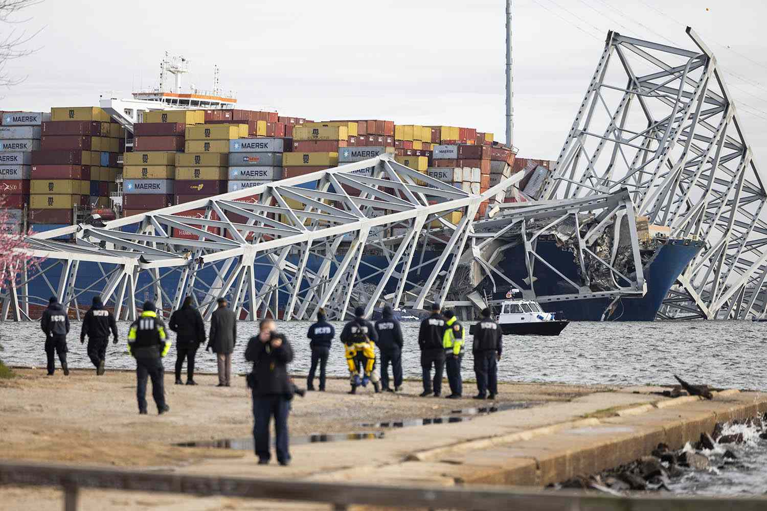 Rescue personnel gather on the shore of the Patapsco River after a container ship ran into the Francis Scott Key Bridge
