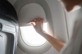 Close-up Woman Hand Open the airplane window while travel