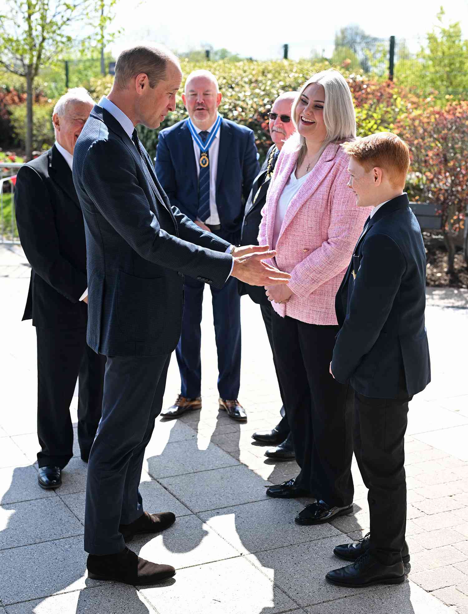 Prince William, Prince of Wales (L) speaks with twelve-year-old Freddie Hadley (R), who made the initial invitation to visit the school, during a visit to St. Michael's Church of England High School in Rowley Regis