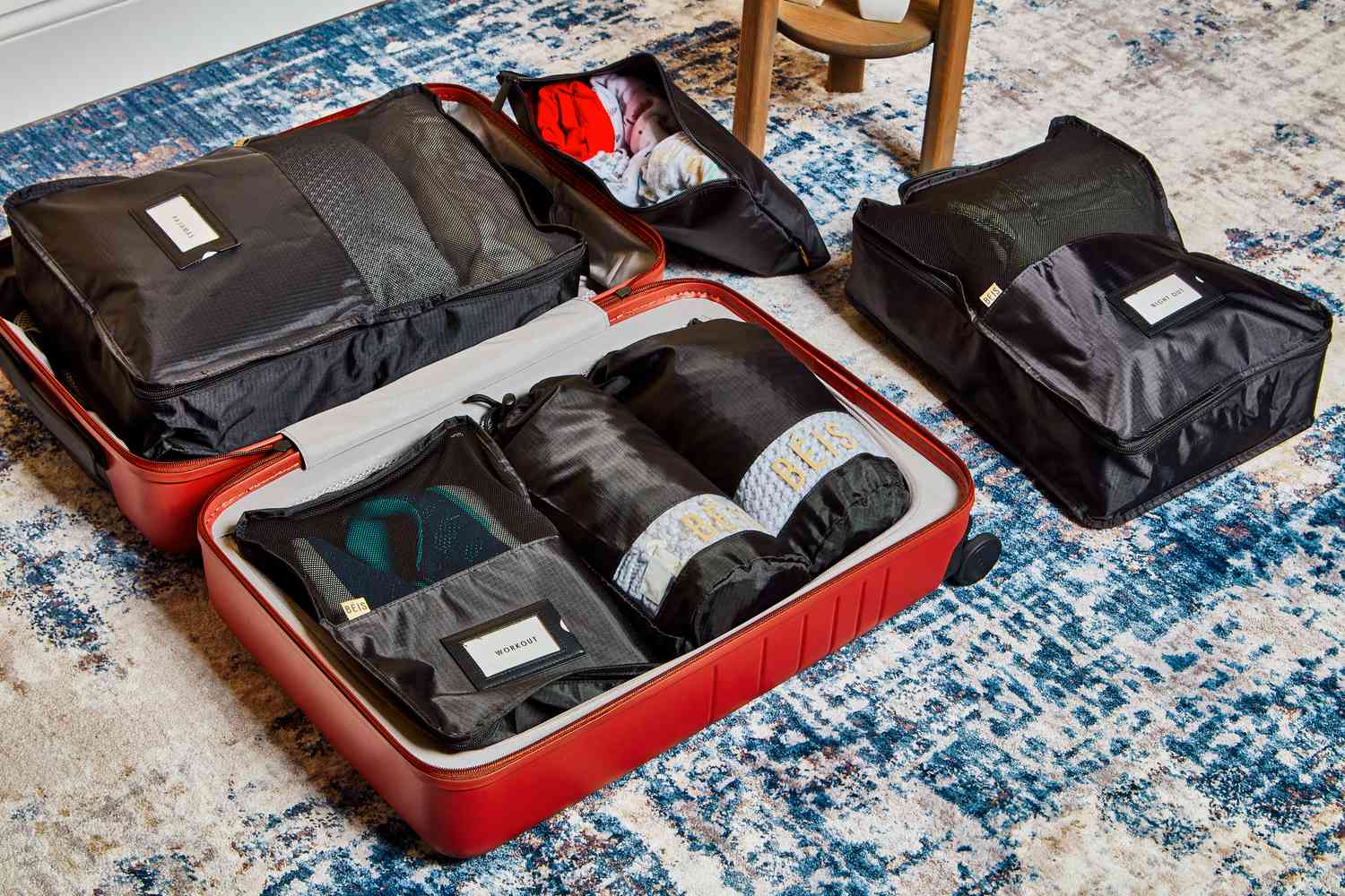 Béis The Packing Cubes inside red suitcase on carpet